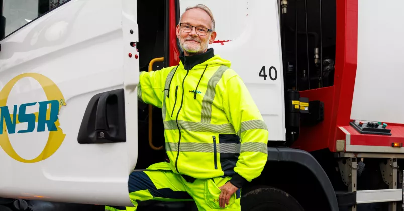 Anders Holmquist i jobbkläder utanför sin sopbil.