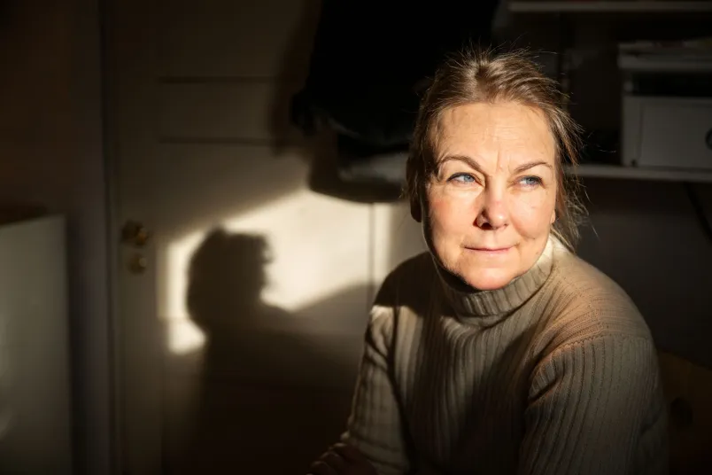 Maria Dahlin blickar ut ur i bild. Hon bär en beige stickad tröja.