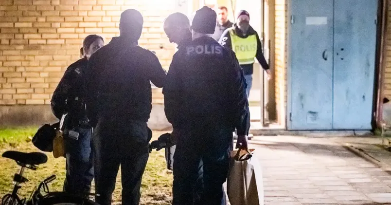 Polis och kriminaltekniker på plats vid ett flerfamiljshus.