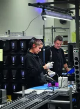 Susanne Westring och Daniel Lambert tillverkar laddstationer för elbilar. Fabriksmiljö, mörka kläder. 