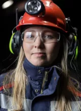 Gruvarbetaren Matilda Niemi i hjälm och skyddskläder. 