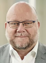 Porträttbild på Harald Petersson, grå kavaj, glasögon.