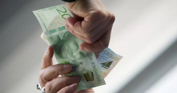 Händer som räcker pengar mellan varandra.