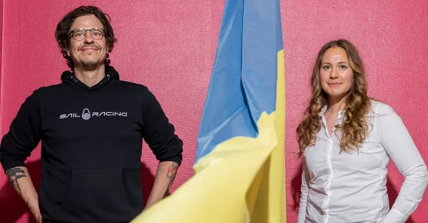 Consid-medarbetarna Frida Eklund och Erik Zetterström bredvid en ukrainsk flagga.
