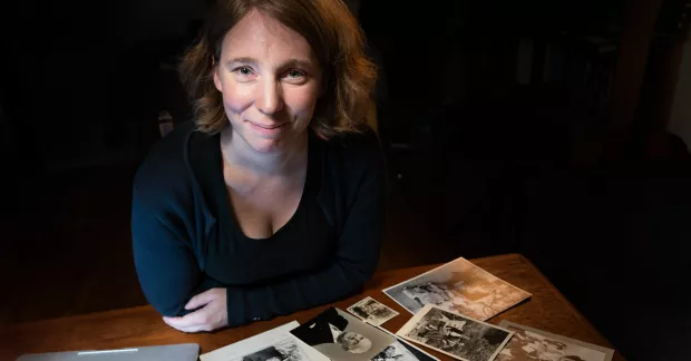 Johanna Lindh sitter vid ett bord med gamla fotografier.