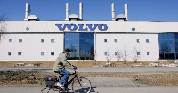 Man cyklar förbi Volvos fabrik i Umeå.