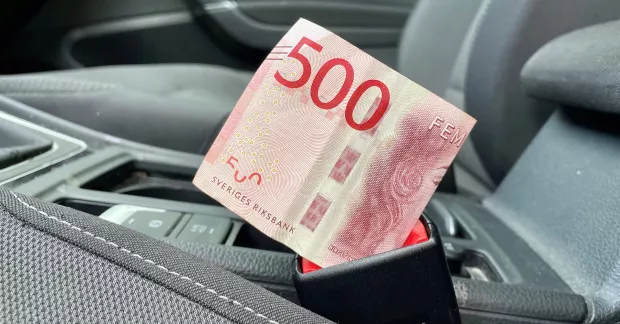 En femhundralapp nedstucken i bilbälteslåset på en personbil. 
