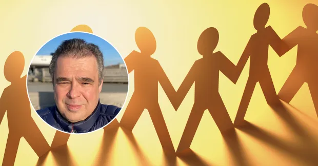 Pappersfigurer som håller varandra i handen