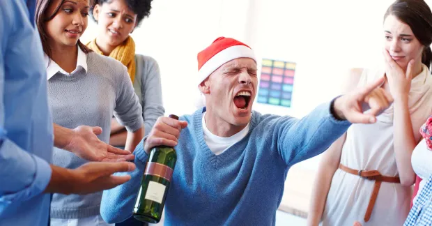 Berusad man_med_tomteluva_och_vinflaska_pa_jobbet