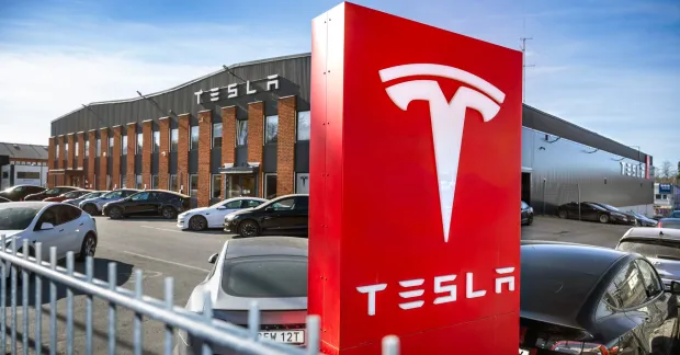 Unionen varslar om ny blockad mot Tesla – WAECO förbjuds utföra arbete från 3 november. Facklig kamp fortsätter för kollektivavtal. En röd Tesla-skylt i fronten mot en byggnad i bakgrunden
