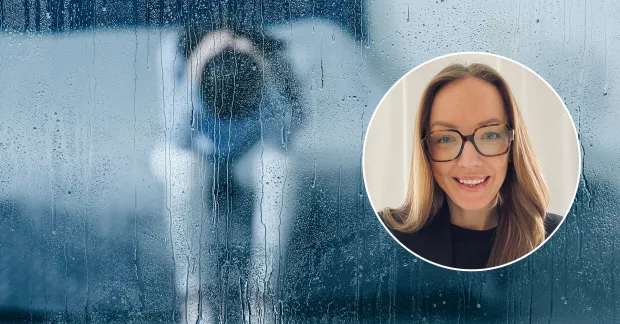 Kvinna sitter lutad över en säng