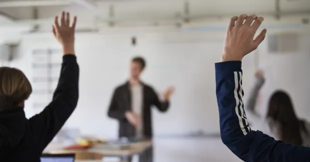 Anställda räcker upp handen under en intern utbildning, en form av kompetensutveckling som enligt IFAU kan öka produktiviteten.