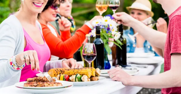 Personer som grillar och skålar