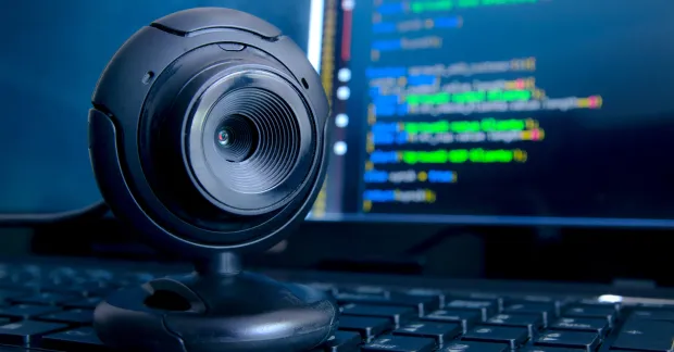 Kamera riktad mot datorarbetsplats, används som illustration för övervakning på jobbet.