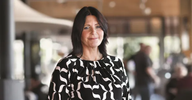 Erica Sundberg, operativ chef på TRR, står i en kontorsmiljö. Bilden kopplar till TRR:s stöd för chefer som söker nytt jobb.