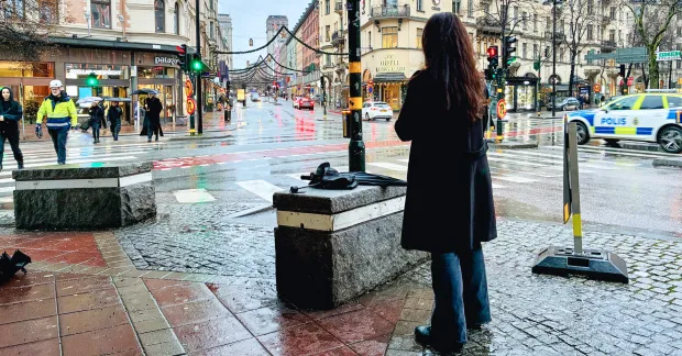 Gatumiljö i centrala Stockholm med en person sedd bakifrån och polisbil i bakgrunden. Bilden illustrerar en arbetsrättslig tvist som lett till ny stämning.