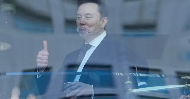 Elon Musk gör tummen upp utanför en amerikansk rättegångssal.