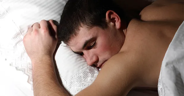 Person som sover på mage i säng – illustrerar återhämtning och sömnens betydelse vid nattarbete.