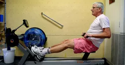 Man på roddmaskin i gym.