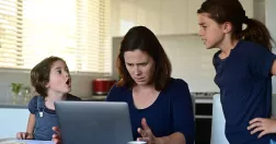 Kvinna vid laptop tillsammans med två barn