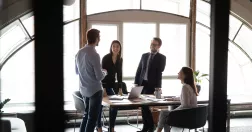 Fyra personer samtalar på ett kontor.