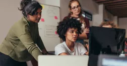 Fyra kvinnor framför en dator.