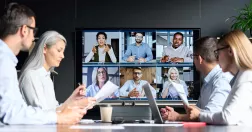 En grupp medarbetare har fysiskt möte och en annan grupp syns på skärm.