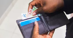 Person tar pengar ur plånbok.