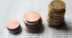 Tre staplar med svenska mynt i olika höjd. Lägst till vänster, näst högst i mitten och högst stapel mynt till höger. 