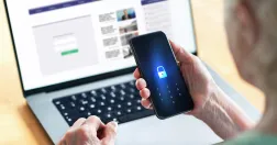 Så undviker du nätfiske efter en dataläcka – expertens varning. PÅ bild en kvinna med bärbar dator och en autentiserigsapp.