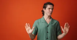 En person håller upp händerna i en stoppande gest, som en symbol för att våga säga nej och sätta gränser på jobbet.