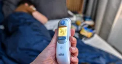 Förälder mäter feber på sjukt barn hemma under vabruari.