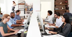 Personer som arbetar i ett öppet kontorslandskap, en kontorstyp som enligt forskning kan öka stress och påverka arbetsmiljön.