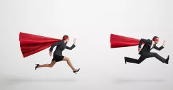 En man och kvinna klädda som superhjältar springer.