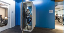 Man pratar i telefon i ett fyttbart och ljudisolerat bås.