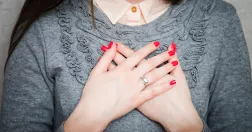 Kvinna håller händerna för bröstet i en hälsning. 