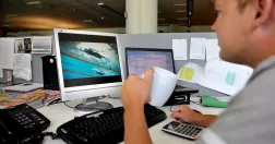 Man kollar sport på sin dator på jobbet.