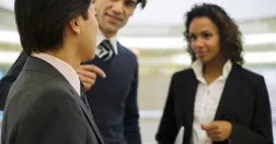 Två män och en kvinna står och pratar.