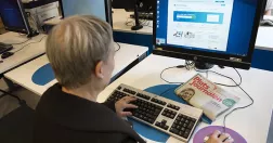 Kvinna sitter vid dator och söker jobb på Arbetsförmedlingen.