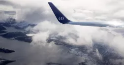 Flygplansvinge med SAS-loggan på plan i luften.