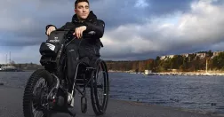 Tobias Forsberg sitter i sin permobil vid vattnet.