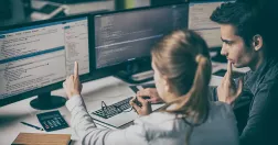 Två webbutvecklare tittar på dataskärm.