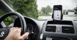 Person åker i bil med gps i mobilen.