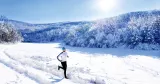 Man löptränar i soligt snölandskap.