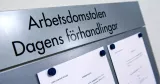 Skylt i grå metall med fastsatta pappersark som visar dagens förhandlingar i Arbetsdomstolen. 