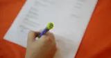 En persons hand syns i bild, den signerar ett dokument