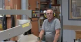 man framför snickerimaskin