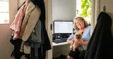 Kvinna med hund i knät framför dator