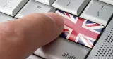 Finger trycker på tangent med brittiska flaggen.